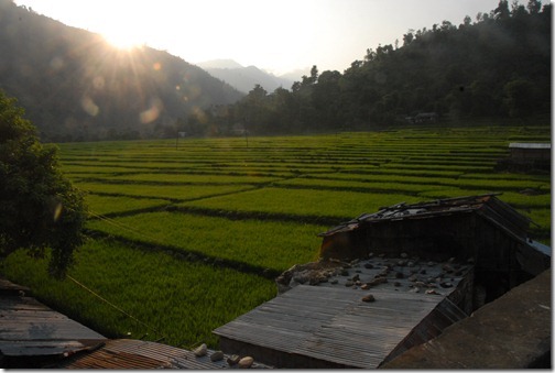 Village with rice paddies just across a suspension footbridge across a Himalayan river near Baireni, Nepal