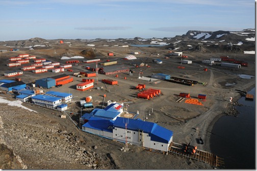 View from the ridge above the Chilean Base Presidente Eduardo Frei Montalva / Villa las Estrellas (houses with blue and orange roofs) and the Russian Bellingshausen Research base (all buildings beyond the road past the white and orange dome.)