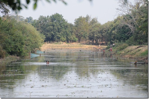 Villagers swimming in the moat around the temple of Beng Mealea, Cambodia