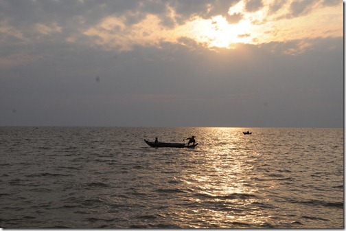 Children fishing at sunset in the floating village of Chong Kneas on Tonlé Sap lake, Cambodia.
