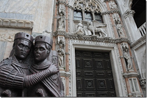 Statue of the Tetrarchs and detail on the front of St. Mark's Basilica, including a Winged Lion of St. Mark in Venice, Italy